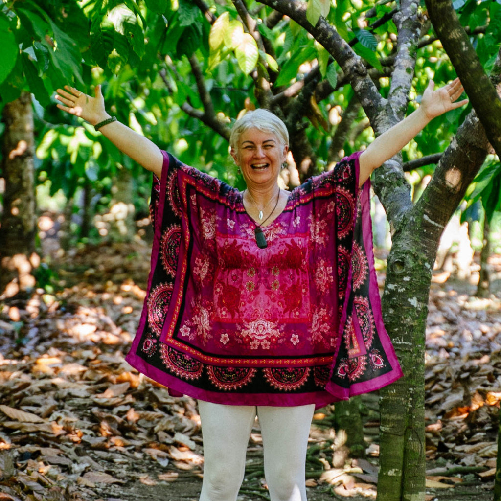 Unagh in a colorful dress standing among trees in a natural setting