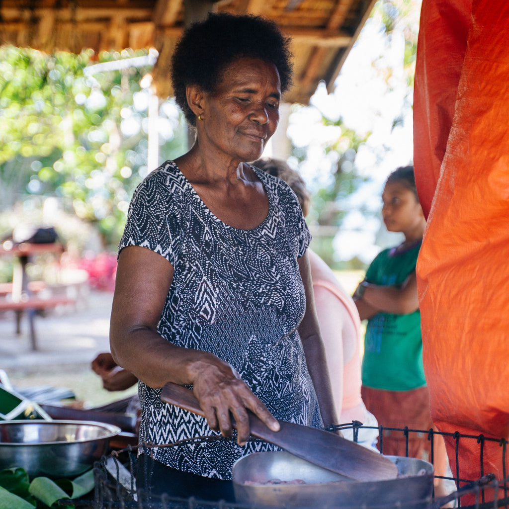 Woman cooking outdoors with a blurred background