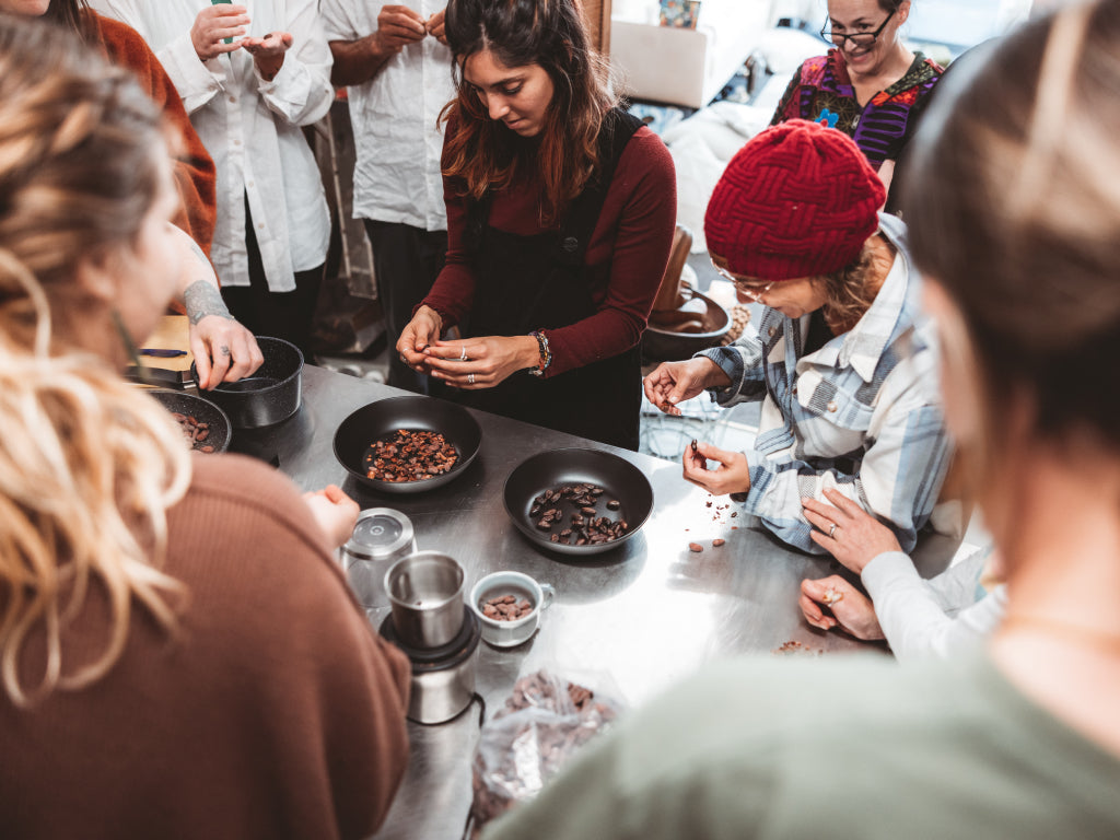 Group of people gathered around a table in a cooking class.